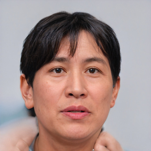 Joyful asian adult male with short  brown hair and brown eyes