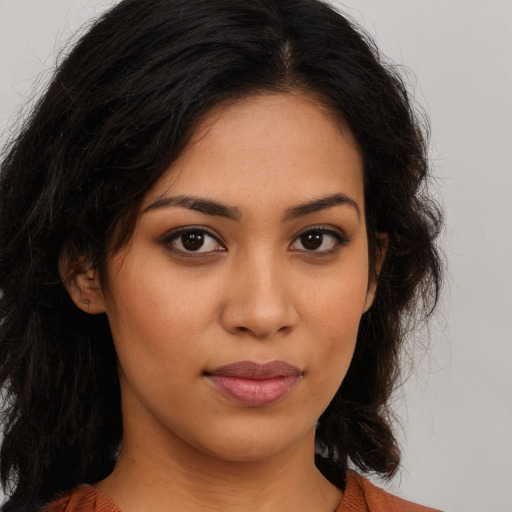 Joyful latino young-adult female with long  brown hair and brown eyes