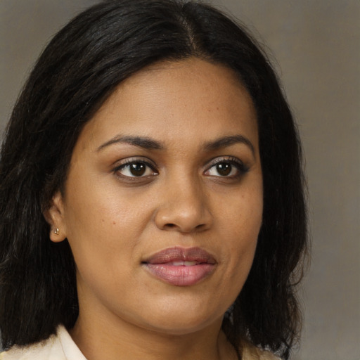 Joyful black young-adult female with long  brown hair and brown eyes