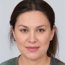 Joyful white young-adult female with medium  brown hair and grey eyes