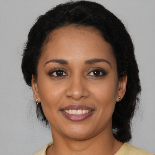 Joyful black young-adult female with short  black hair and brown eyes