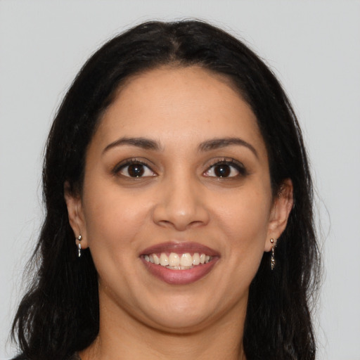 Joyful latino young-adult female with long  brown hair and brown eyes