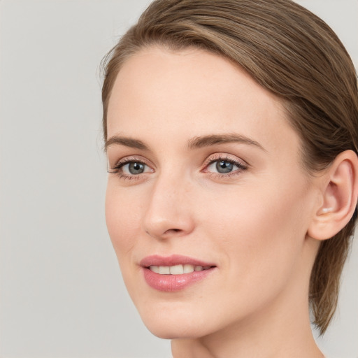 Joyful white young-adult female with medium  brown hair and grey eyes