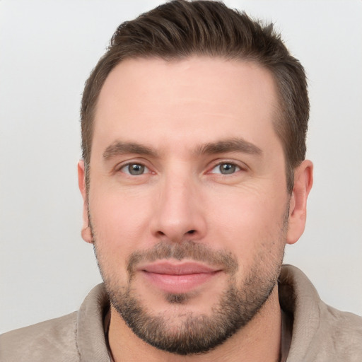 Joyful white young-adult male with short  brown hair and grey eyes