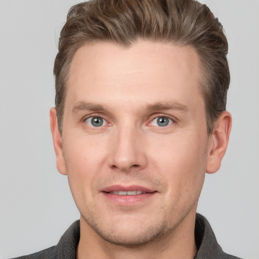 Joyful white young-adult male with short  brown hair and grey eyes