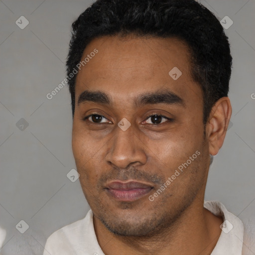 Joyful latino young-adult male with short  black hair and brown eyes