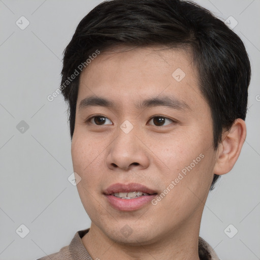 Joyful asian young-adult male with short  brown hair and brown eyes