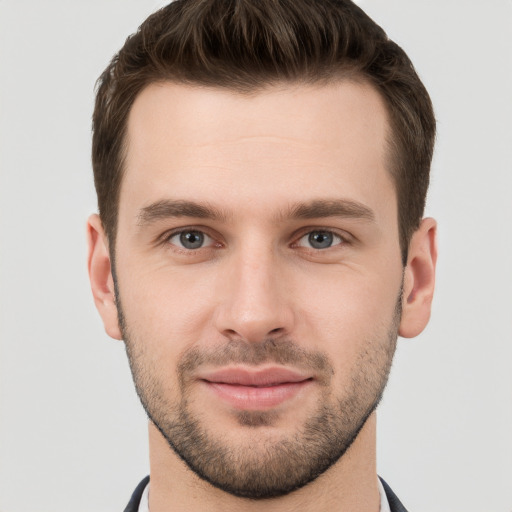 Joyful white young-adult male with short  brown hair and grey eyes