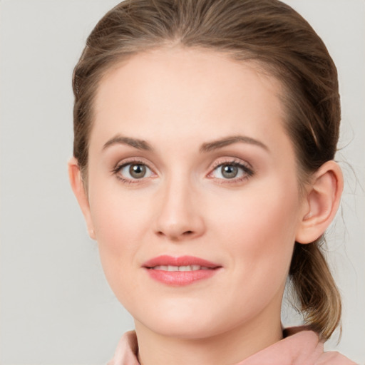 Joyful white young-adult female with medium  brown hair and grey eyes