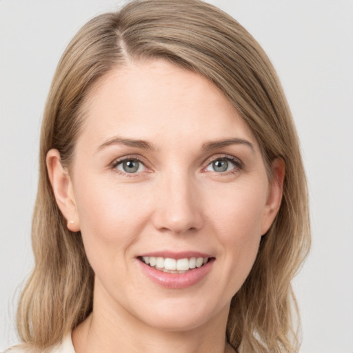 Joyful white young-adult female with medium  brown hair and blue eyes