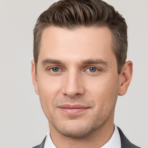 Joyful white young-adult male with short  brown hair and grey eyes