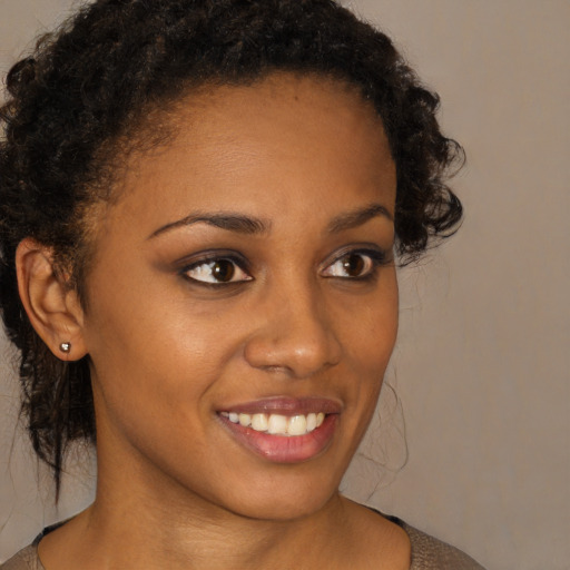 Joyful black young-adult female with short  brown hair and brown eyes