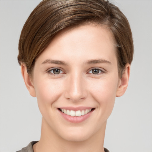 Joyful white young-adult female with short  brown hair and grey eyes