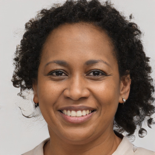 Joyful black adult female with medium  brown hair and brown eyes