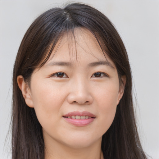 Joyful asian young-adult female with long  brown hair and brown eyes