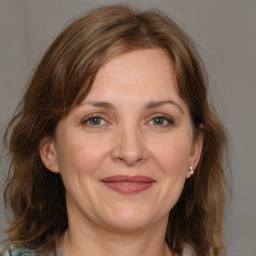 Joyful white adult female with medium  brown hair and grey eyes