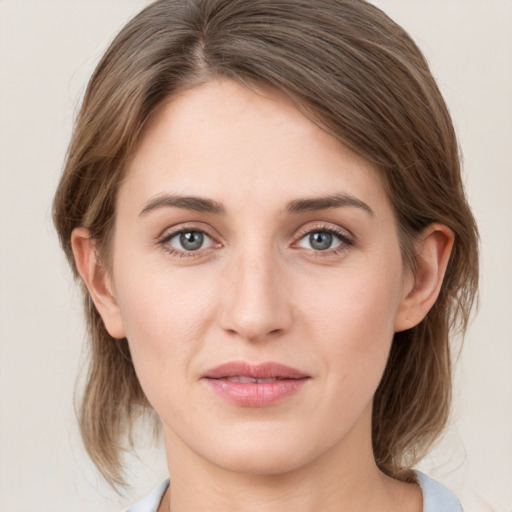 Joyful white young-adult female with medium  brown hair and grey eyes