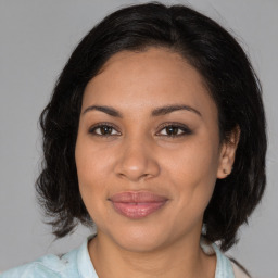 Joyful latino adult female with medium  brown hair and brown eyes