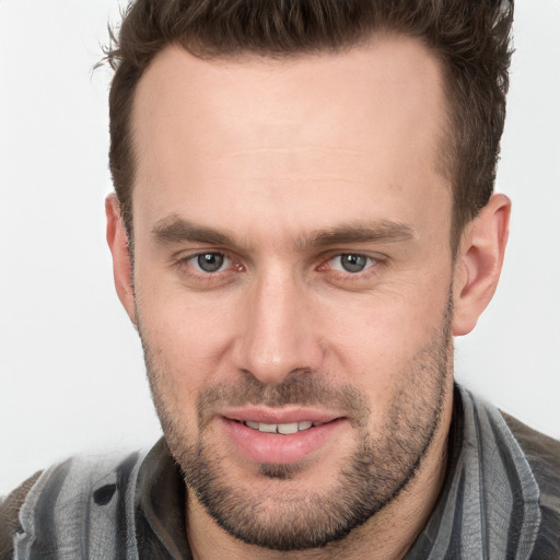 Joyful white young-adult male with short  brown hair and grey eyes