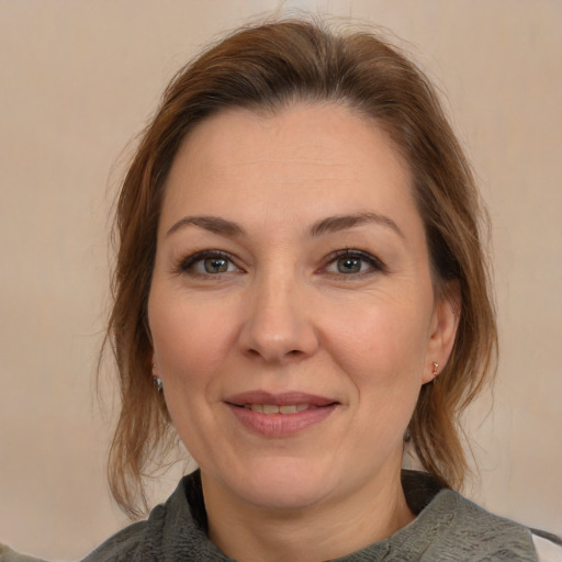 Joyful white adult female with medium  brown hair and brown eyes