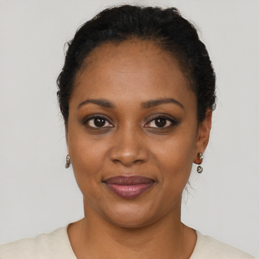 Joyful black young-adult female with short  black hair and brown eyes