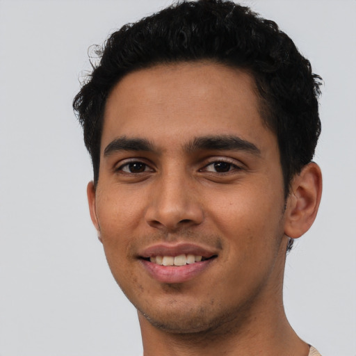 Joyful latino young-adult male with short  brown hair and brown eyes