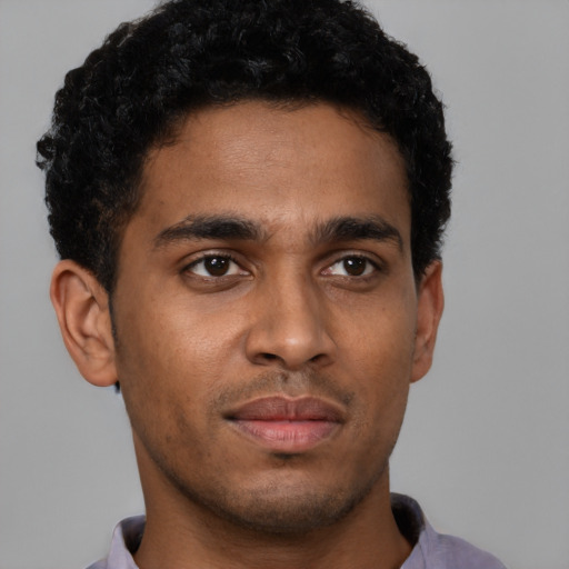 Joyful latino young-adult male with short  brown hair and brown eyes