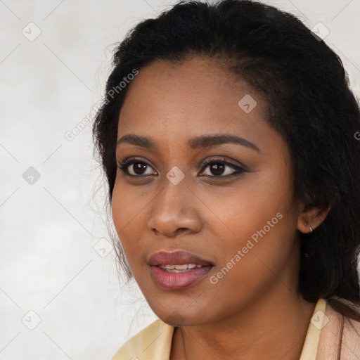 Joyful black young-adult female with long  black hair and brown eyes