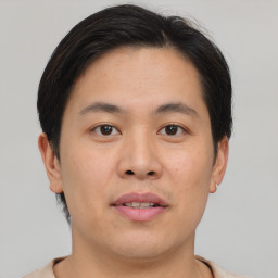 Joyful asian young-adult male with short  brown hair and brown eyes