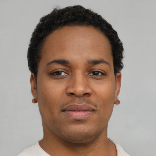Joyful black young-adult male with short  brown hair and brown eyes