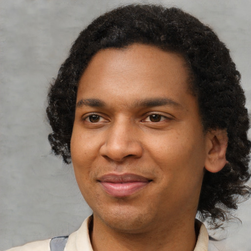 Joyful black young-adult male with short  brown hair and brown eyes