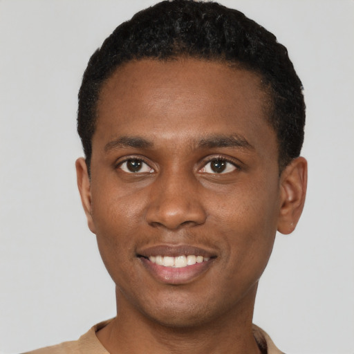 Joyful black young-adult male with short  black hair and brown eyes