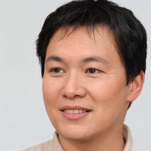Joyful asian adult male with short  brown hair and brown eyes
