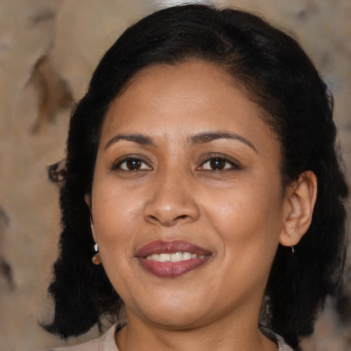 Joyful black adult female with medium  brown hair and brown eyes