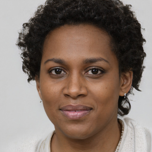 Joyful black young-adult female with short  brown hair and brown eyes