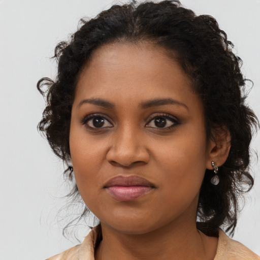 Joyful black young-adult female with long  brown hair and brown eyes