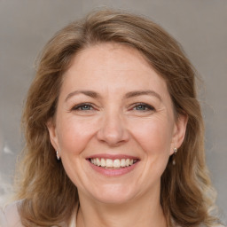 Joyful white adult female with medium  brown hair and grey eyes