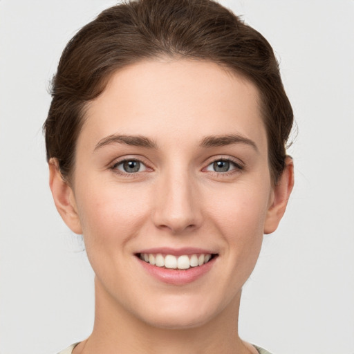 Joyful white young-adult female with short  brown hair and grey eyes