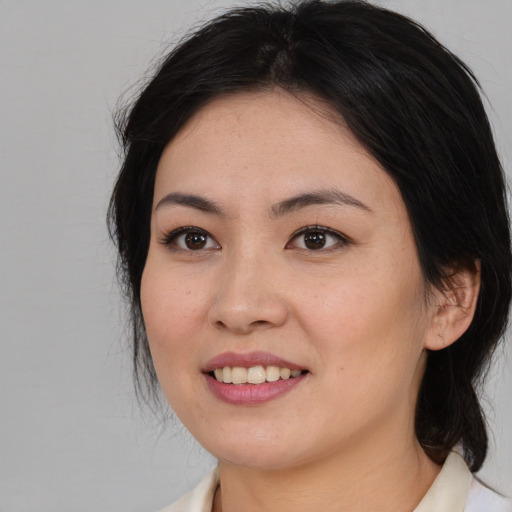 Joyful asian young-adult female with medium  brown hair and brown eyes