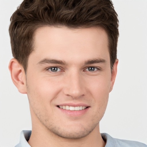 Joyful white young-adult male with short  brown hair and grey eyes