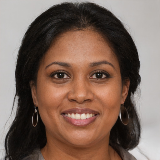 Joyful black adult female with medium  brown hair and brown eyes