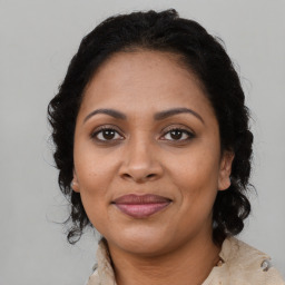 Joyful black adult female with medium  brown hair and brown eyes