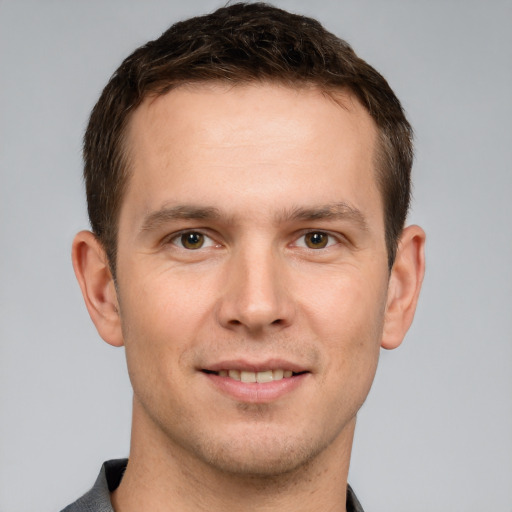 Joyful white young-adult male with short  brown hair and grey eyes