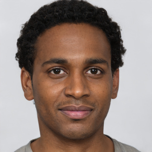 Joyful black young-adult male with short  brown hair and brown eyes