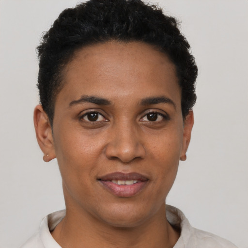 Joyful black young-adult female with short  black hair and brown eyes
