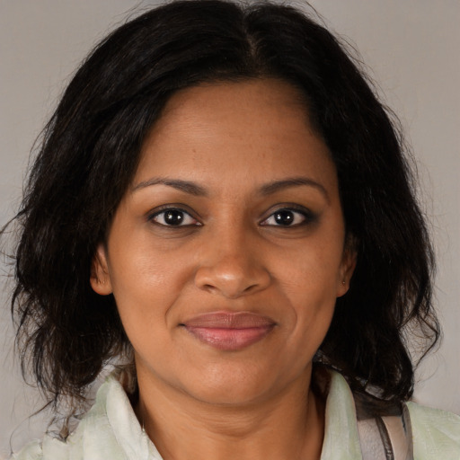 Joyful black adult female with medium  brown hair and brown eyes