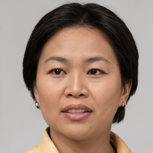 Joyful asian adult female with medium  brown hair and brown eyes