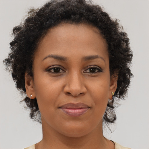 Joyful black young-adult female with long  brown hair and brown eyes