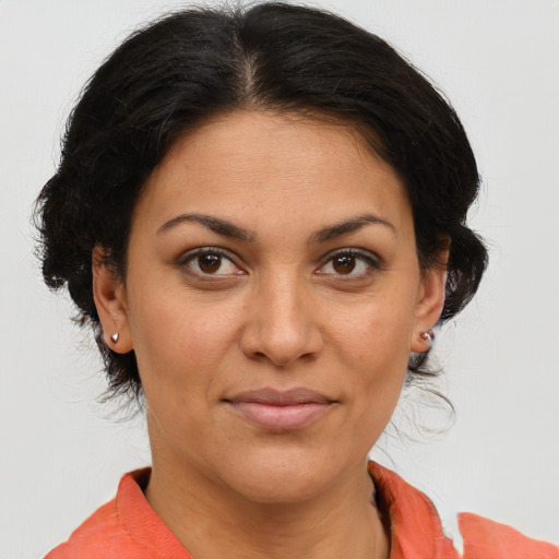Joyful latino adult female with medium  brown hair and brown eyes