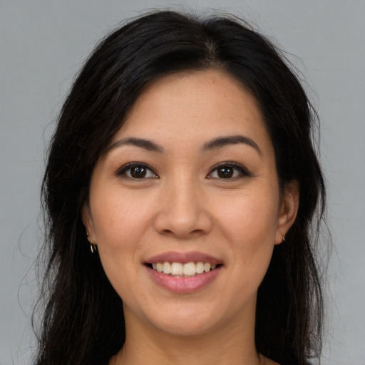 Joyful latino young-adult female with long  brown hair and brown eyes